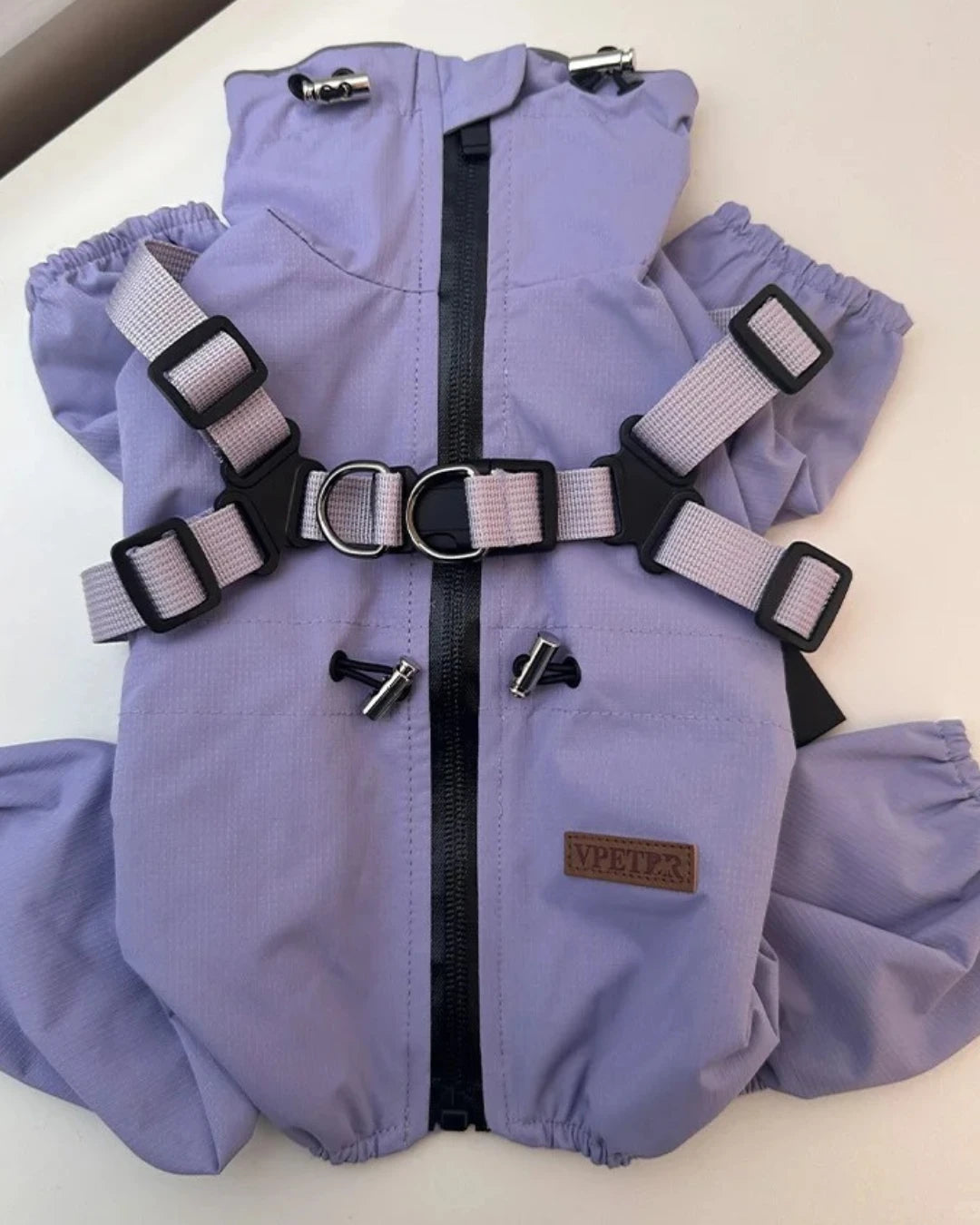 Zipper securely fastened, purple dog coat neatly folded and stored.